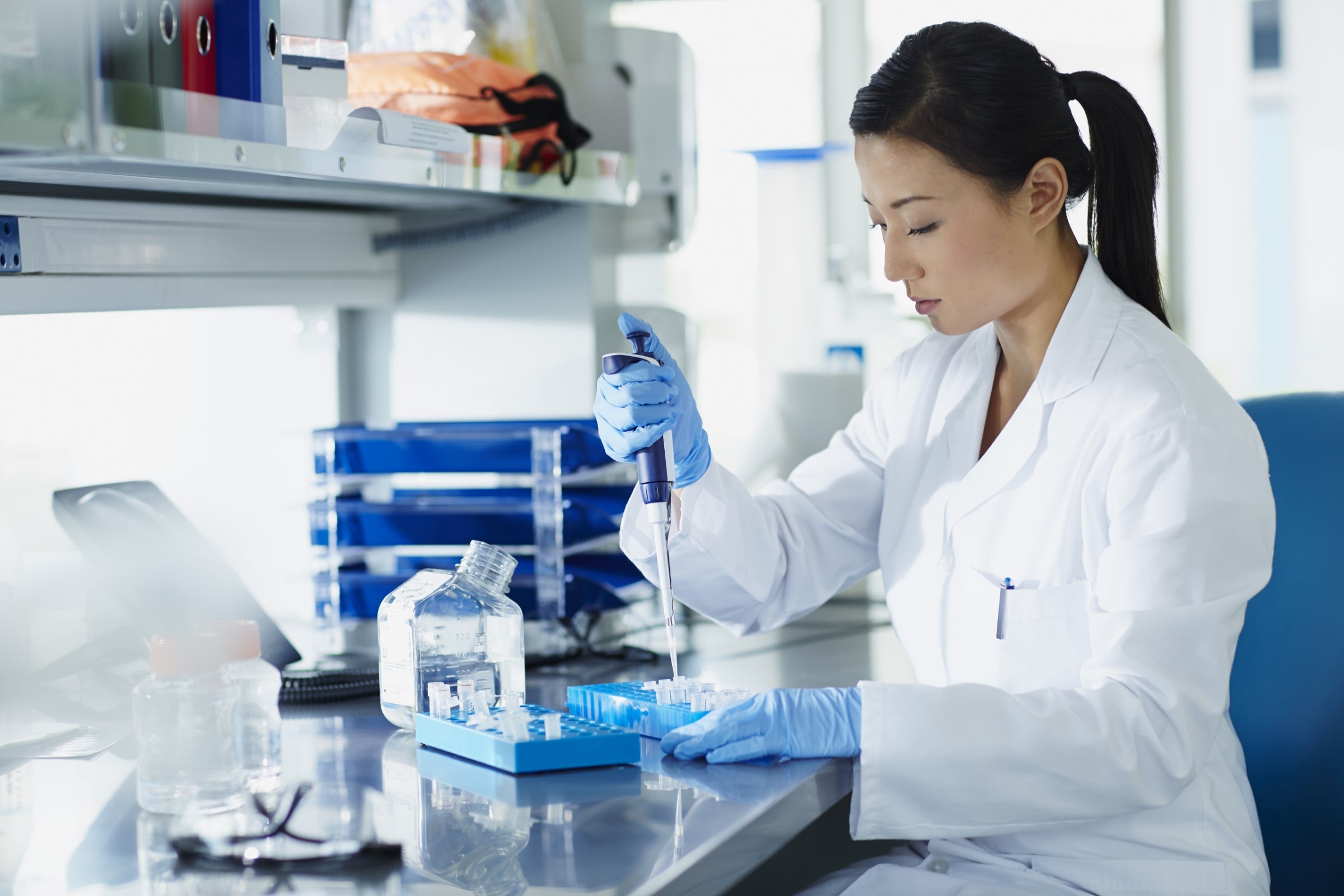 Scientist pipetting samples into tubes.