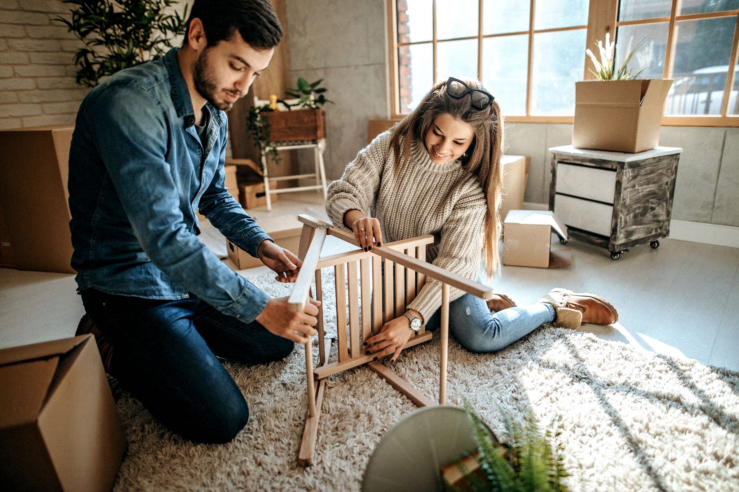 Young couple assembling furniture for new home