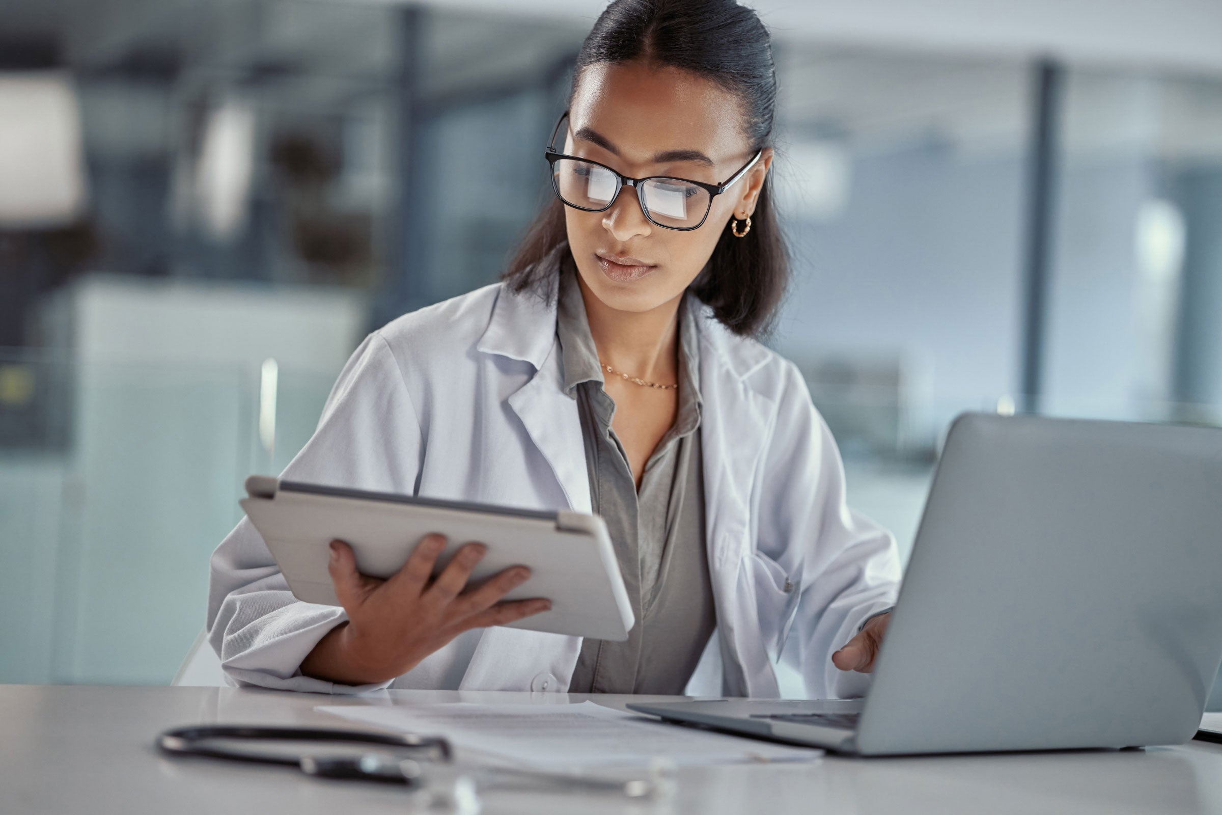 A doctor using multiple electronic devices