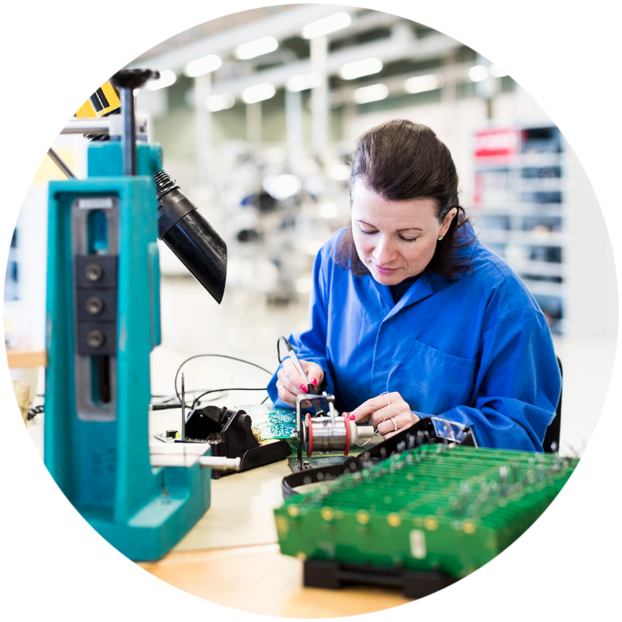 Electrician working on circuit board at a desk