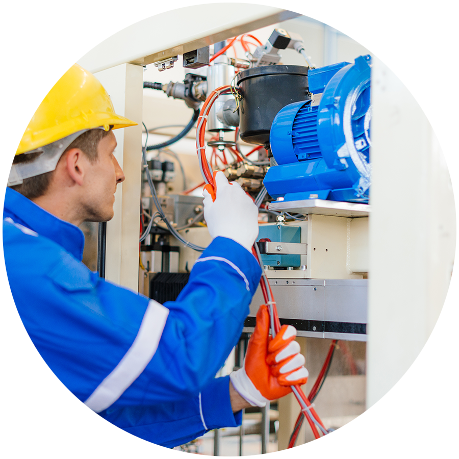 Electrician checking wires and cables on a machine in a factory