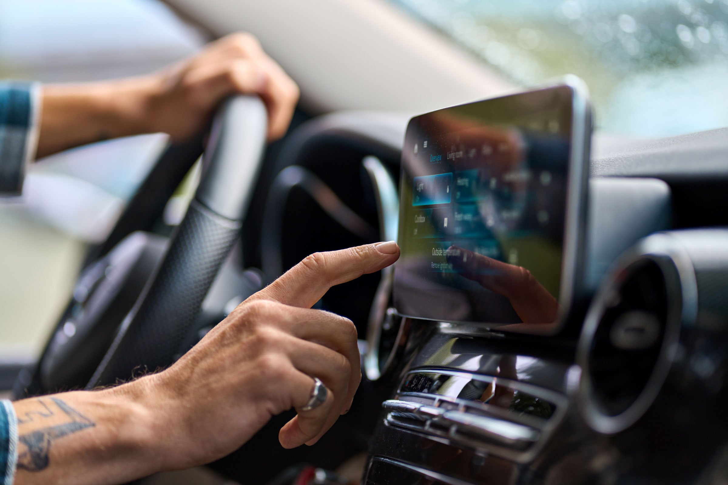 A person using a screen in a car