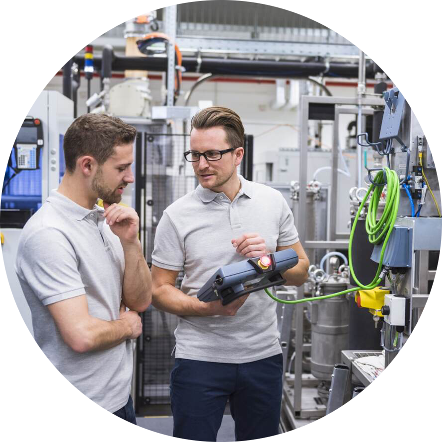 Two engineers working with a control system on factory shop floor