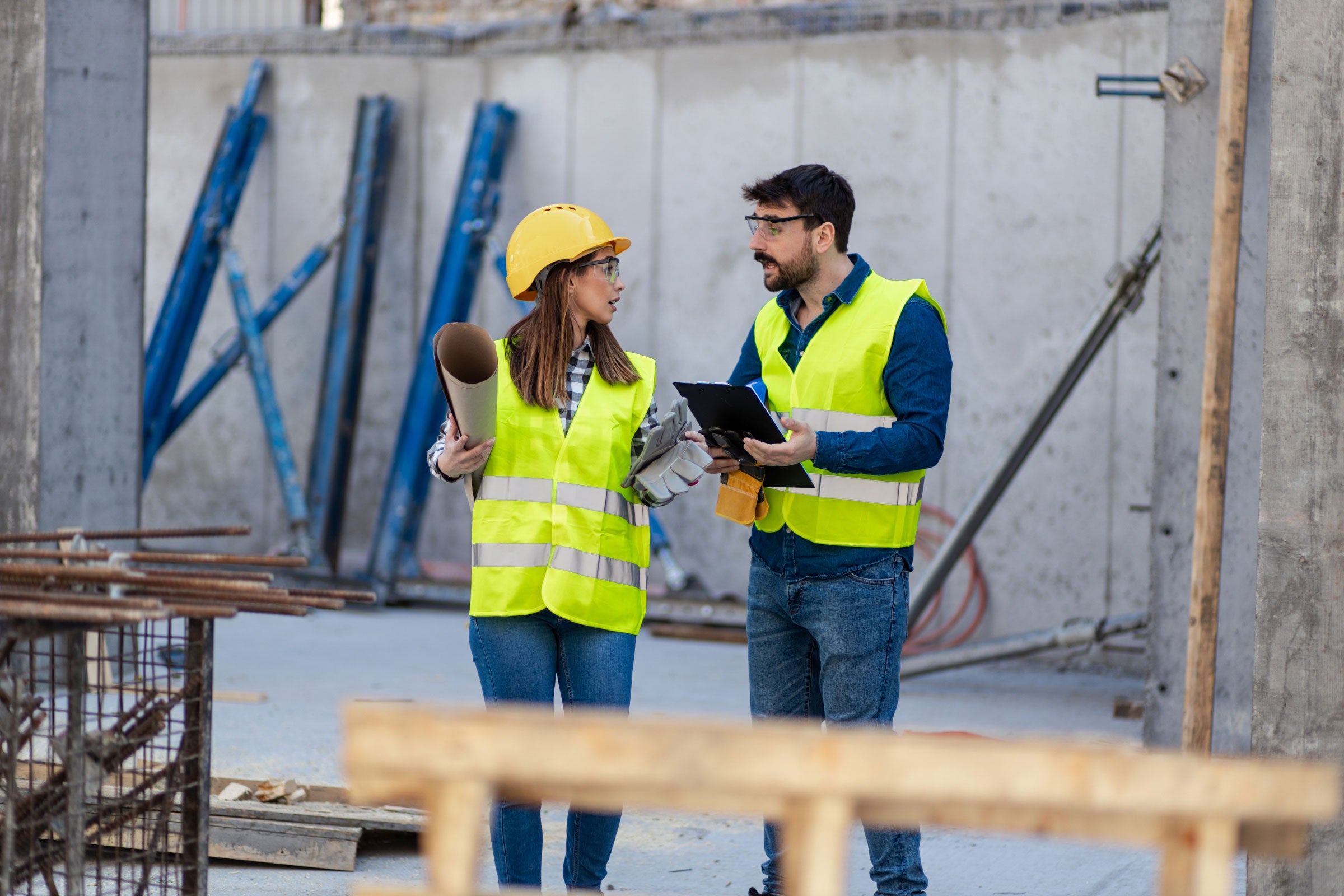 Two people walking a construction site while having a discussion 