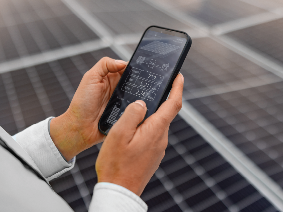 person measuring energy levels with their cell phone near an array of solar panels