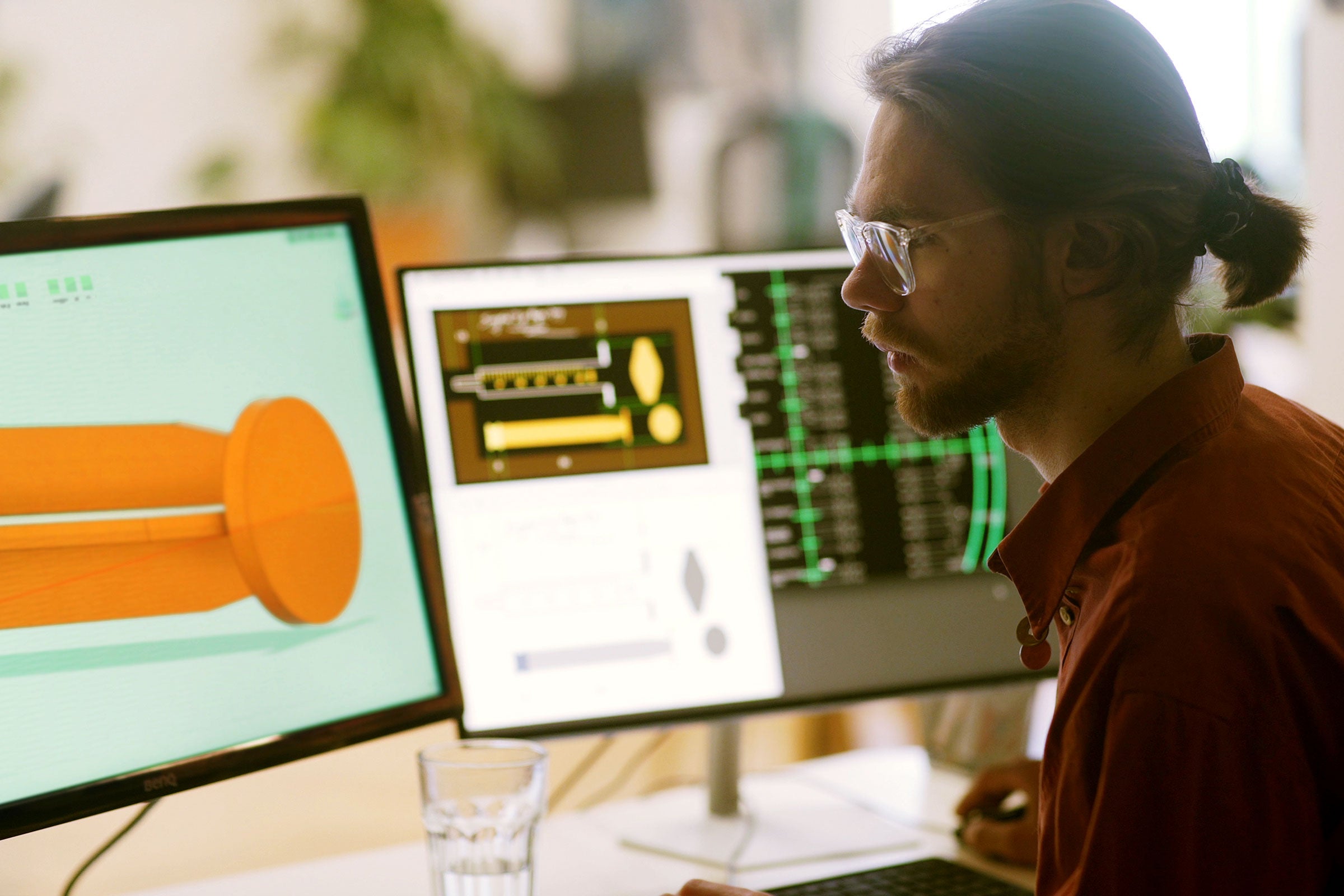 Person working on CAD software designing a medical syringe