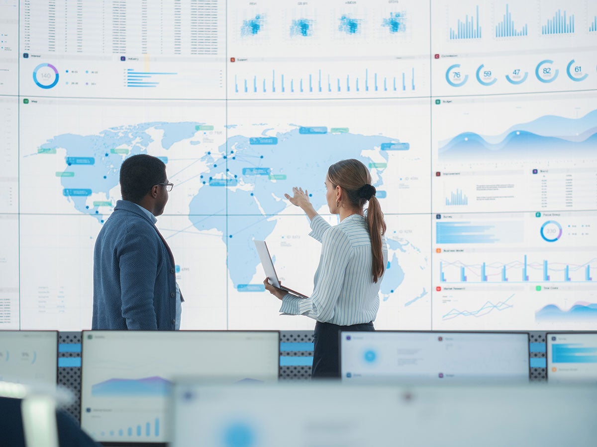 Two analysts looking at metrics on a digital map