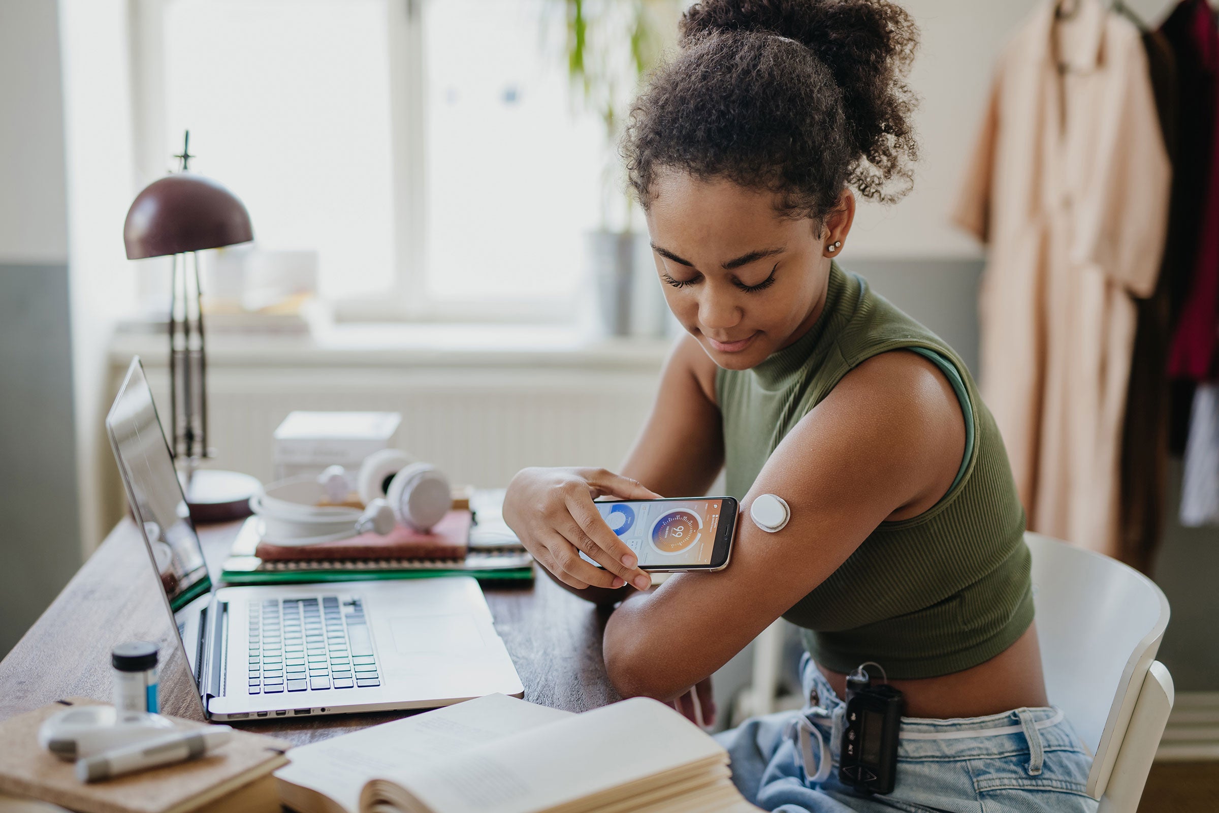 Person connecting their smartphone to a continuous glucose monitor to check their blood glucose levels