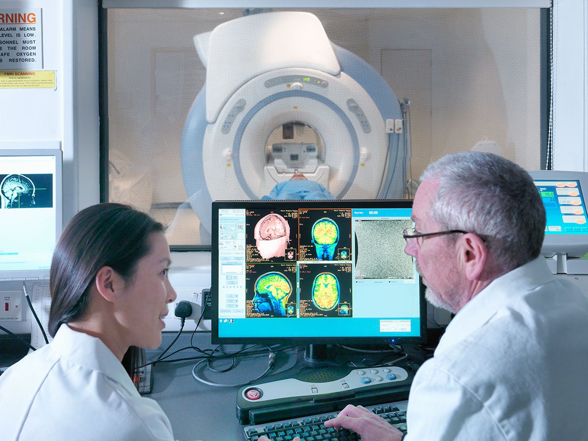 Medical professionals using an Magnetic Resonance Imaging (MRI) 3 Tesla twin speed scanner to take images of a patient's brain