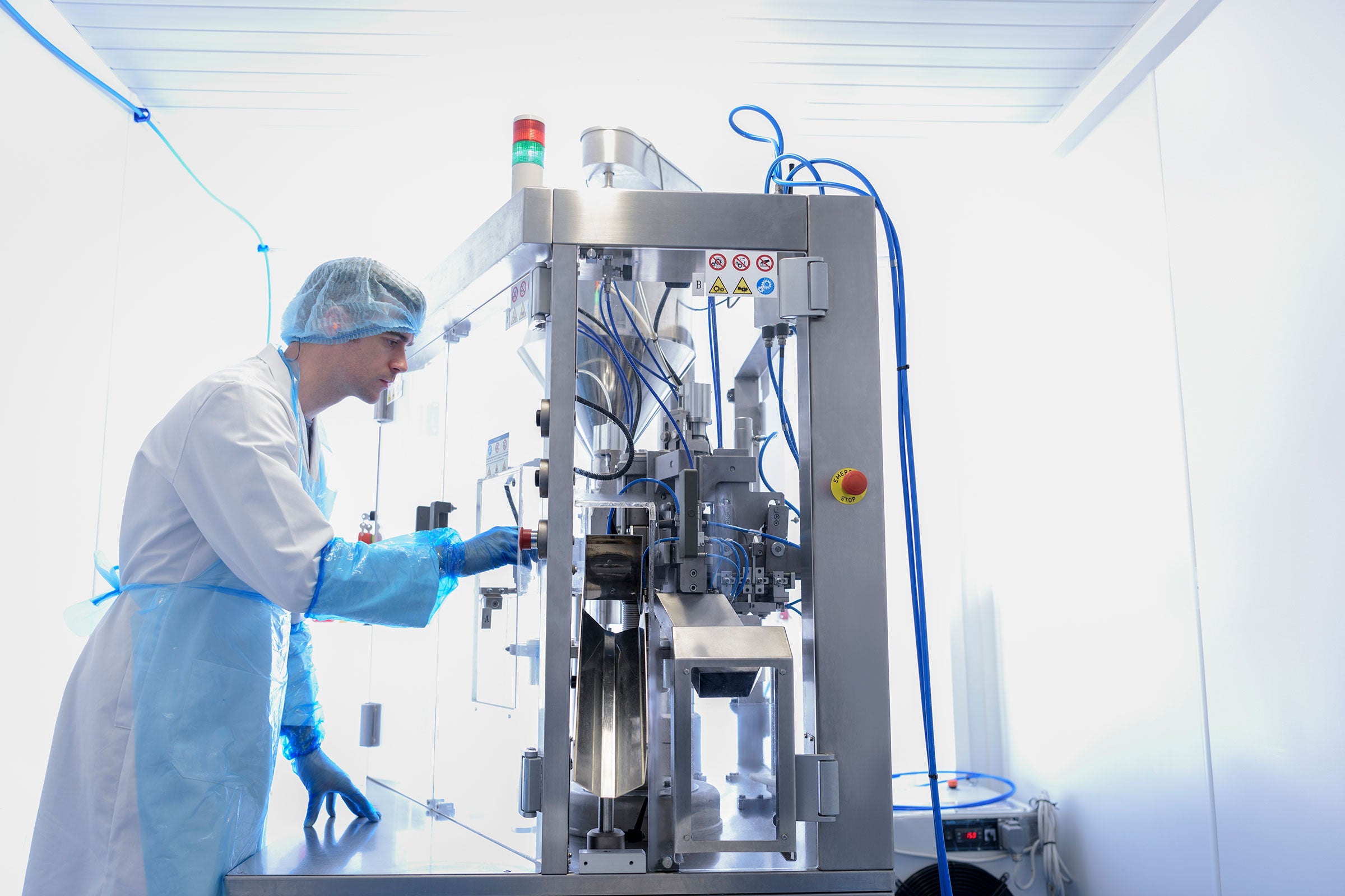 Technician using a gel filling machine in pharmaceutical factory