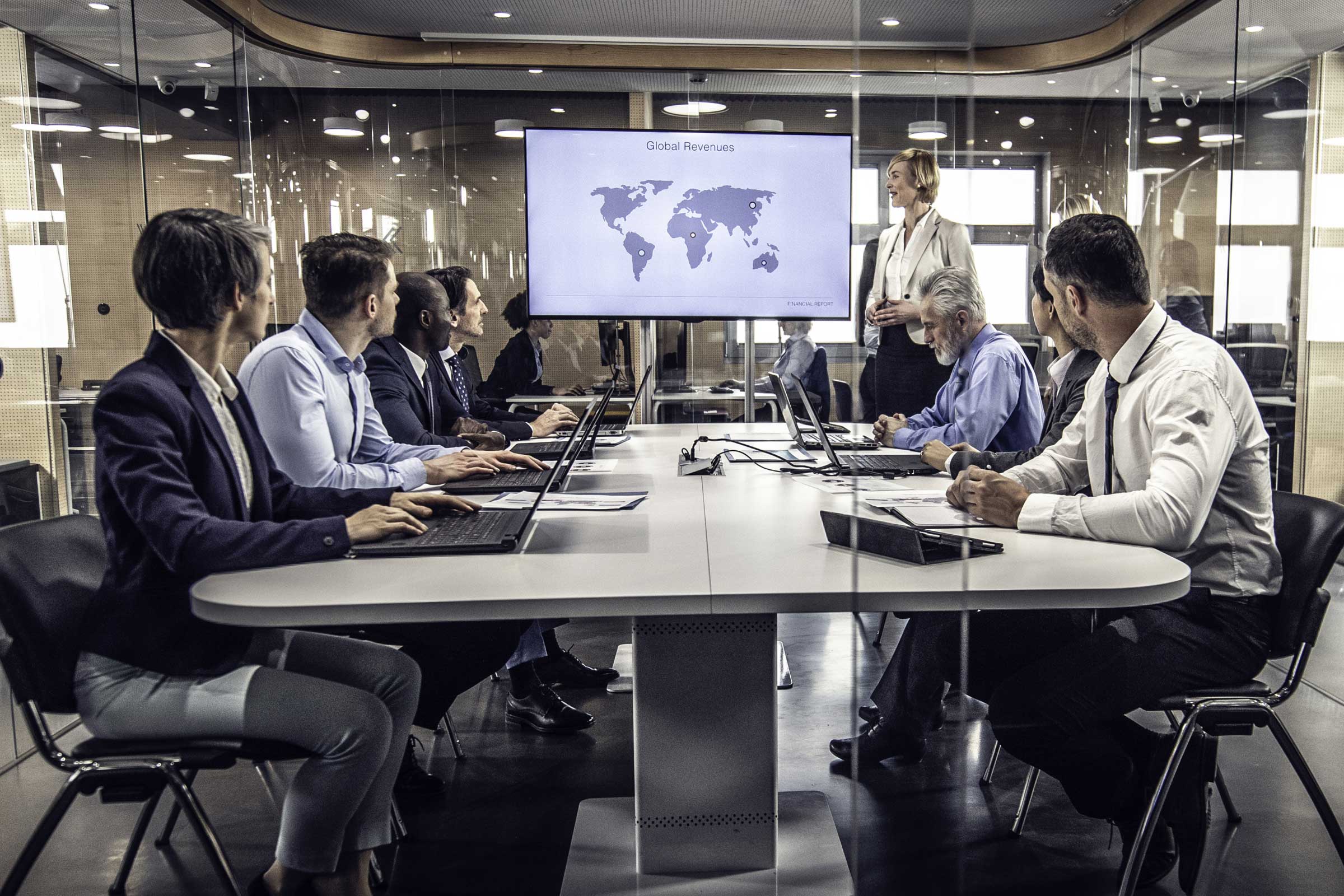 Group of business professionals having a meeting while looking at a map of the world