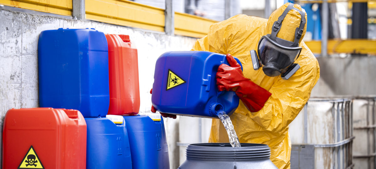 person in hazmat suit pouring toxic chemical into a container