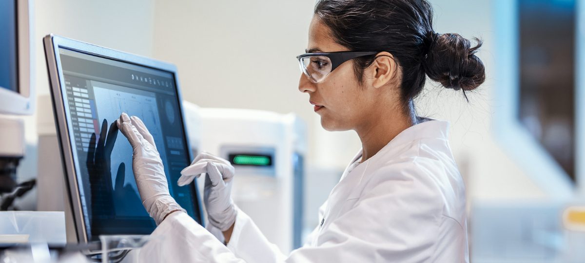 scientist with safety glasses using touchpad device