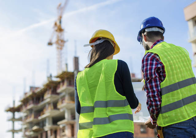 Two architects look at building.