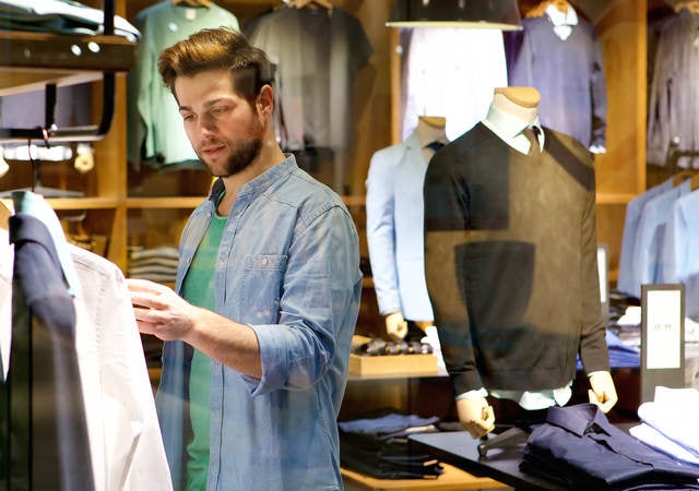 A man browses different articles of clothing.