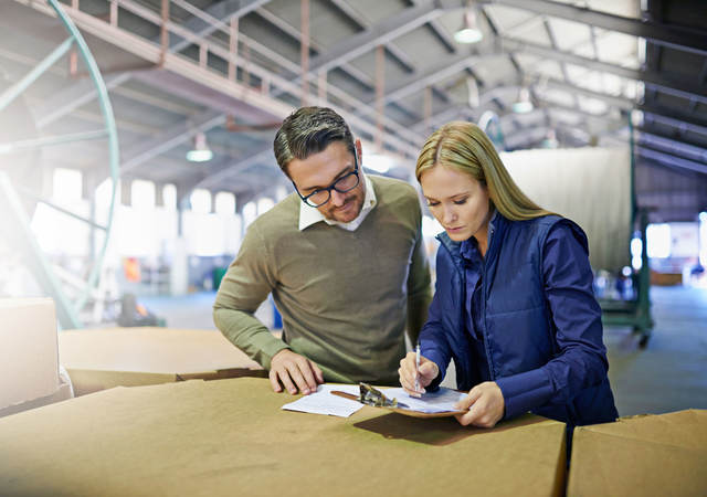 A Man and a woman look at something together in workplace