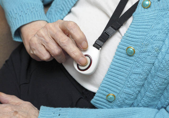 Elderly woman demonstrating call button worn on neck strap