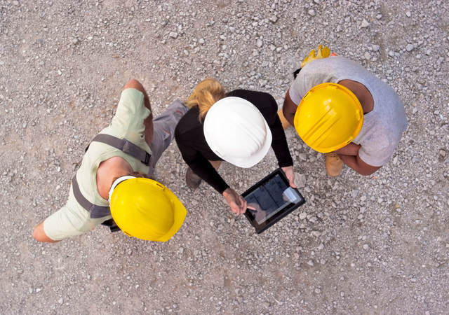 Workers on-site collaborating on a tablet