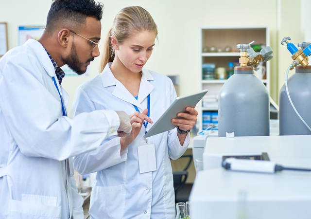 Researchers looking at data on a tablet