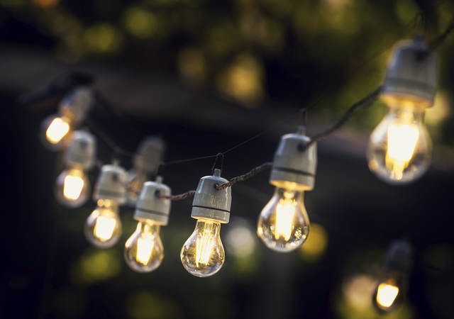 A strand of string lights in an outdoor setting. 