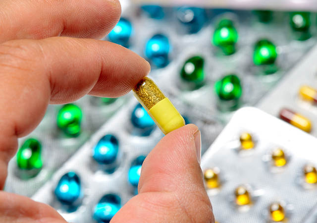 Close-up of hand holding a pill