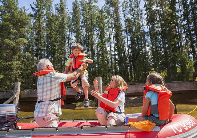 Family wearing personal flotation devices in a raft.