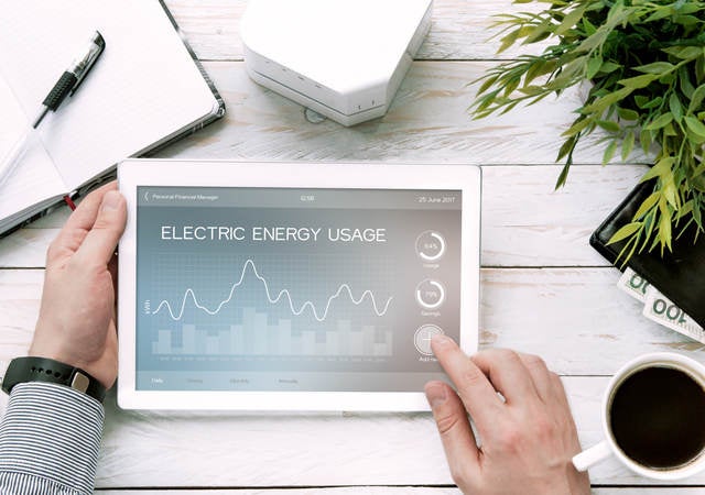 Man holds tablet PC with electric energy usage application