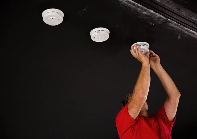 UL engineer installing smoke detectors for testing