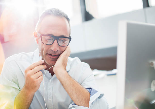 image of a man talking on a phone near a computer