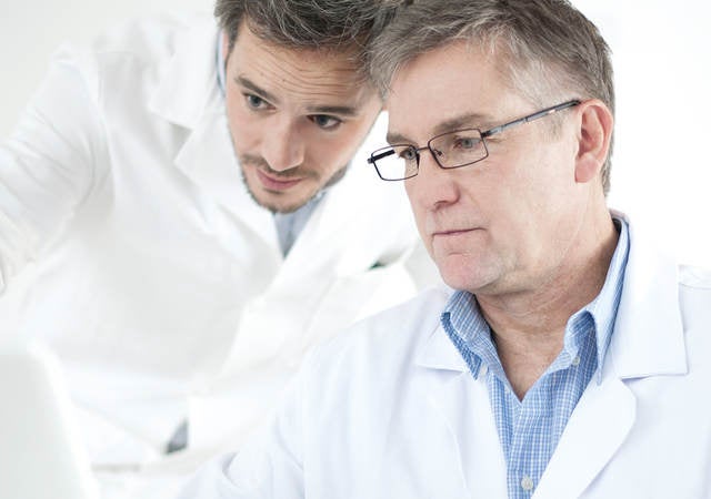 Two scientists work on a computer.