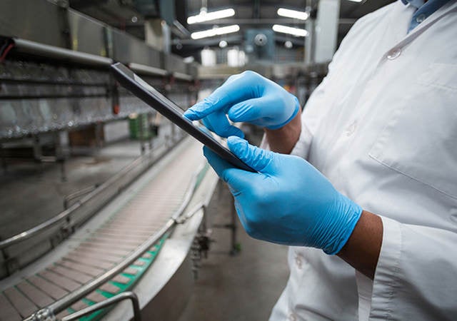 People collaborating on a tablet in a warehouse 