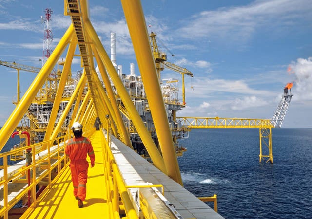 A worker walking on a platform of an offshore rig. 