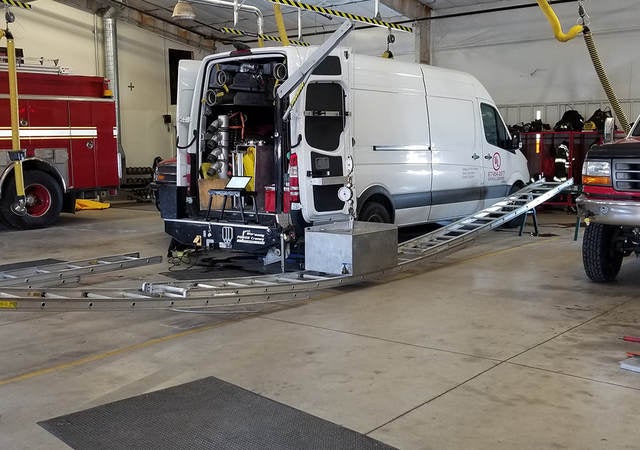 A ladder being tested bearing the weight of a heavy object in a fire department.