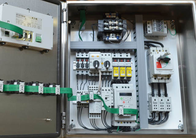 An opened industrial control panel showing components