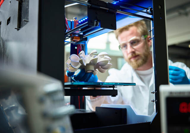 Photo of a scientist testing 3D printed plastic object