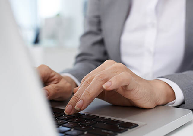 Photo of a woman typing on a laptop