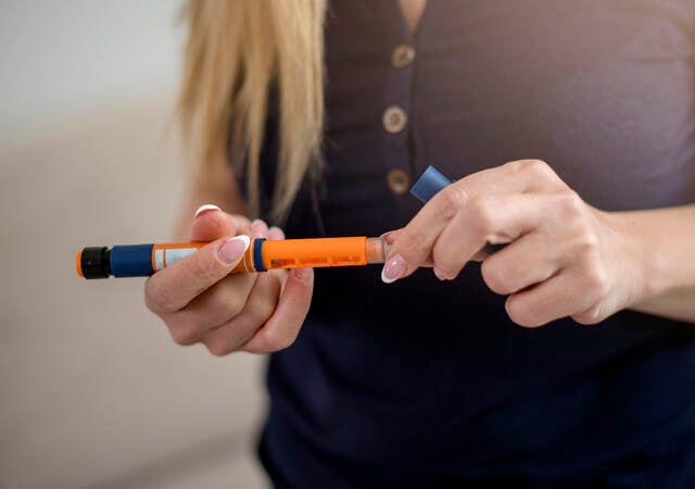 woman holding insulin injector pen