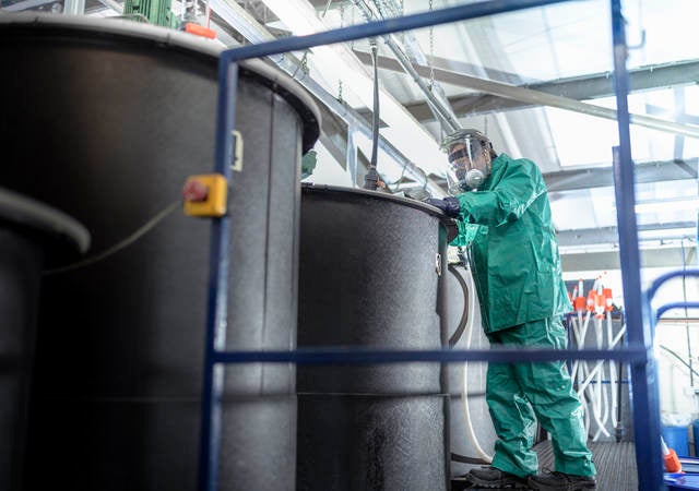 Worker at mixing tanks in chemical factory