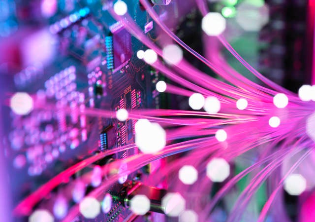 Pink colored fiber spreading into an electronic circuit board