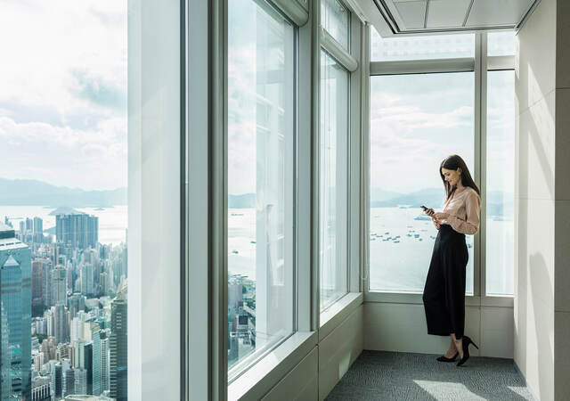 Woman reading near large windows