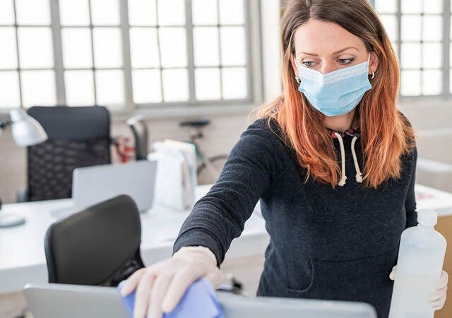 Photo of a woman cleaning a monitor