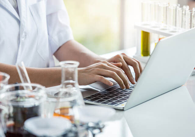 Person working on laptop at lab bench