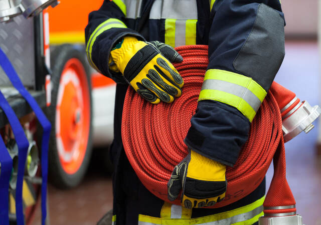 Photo of a firefighter holding a firehose