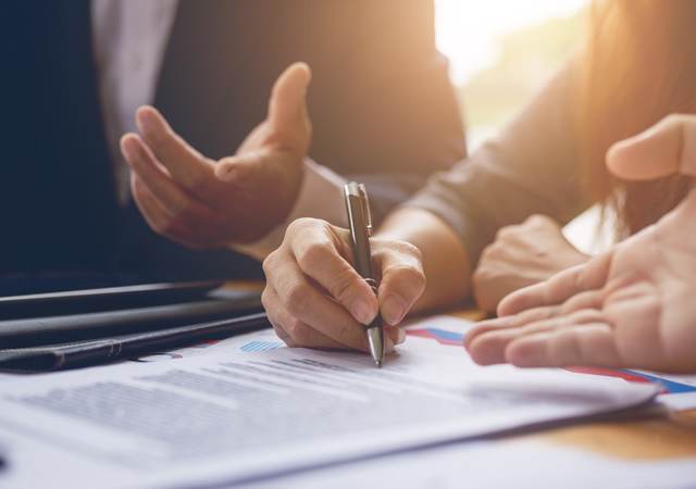 Photo of a person signing a contract