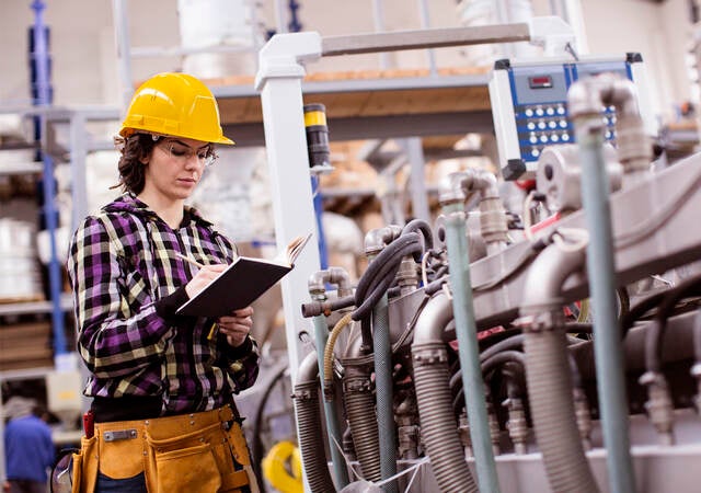 female engineer inspects industrial equipment