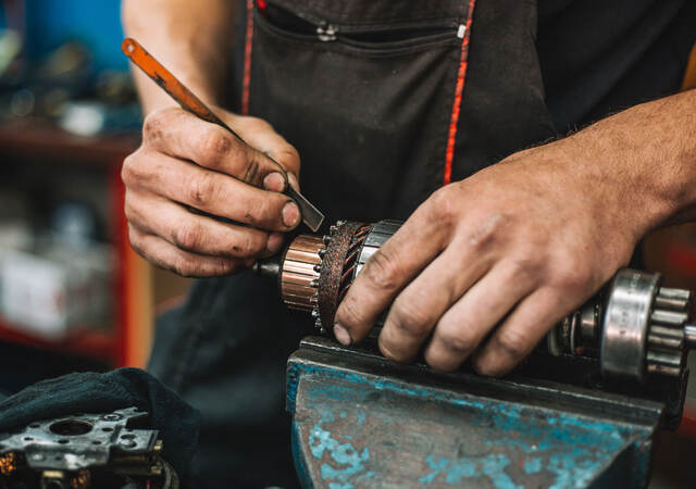 Manual worker repairing electric motor in a workshop