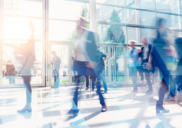 Business people walking in the lobby of a building with glass windows