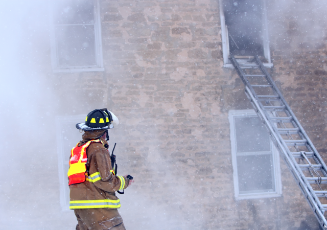 firefighter with radio at burning building