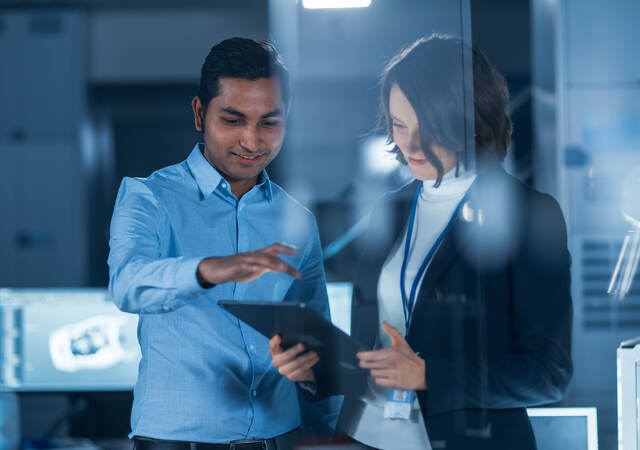 A man and woman looking at a digital tablet