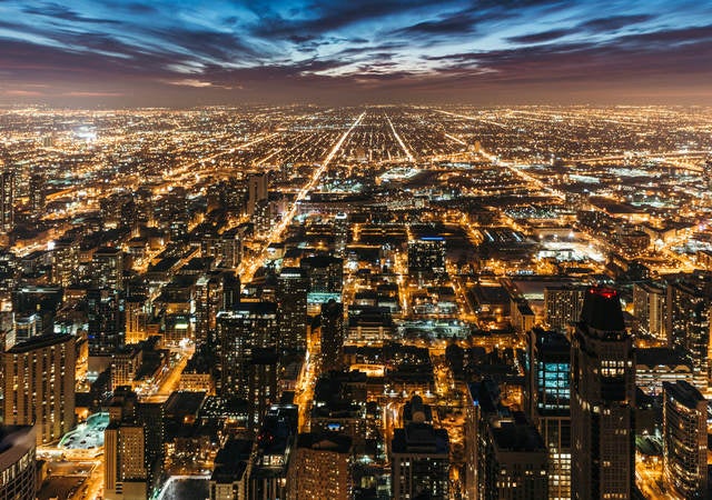 Cityscape at night with many lights from homes, businesses, roads